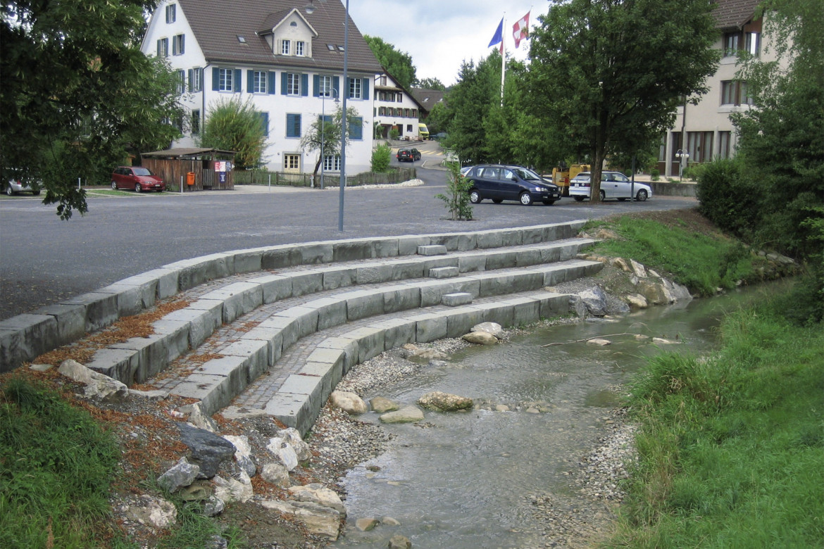 Aufgeweiteter Haselbach beim Dorfplatz mit Stufen als Zugang